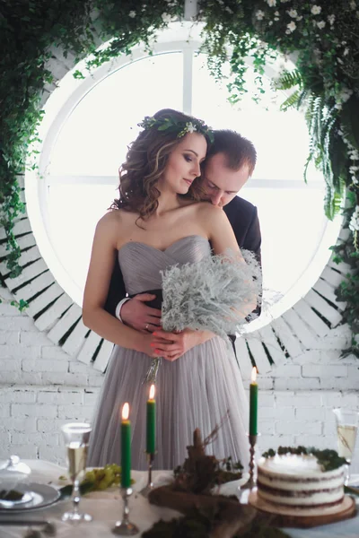 Νύφη και ο γαμπρός σε κομψό γκρι και πράσινο στυλ πάνω από οικολογική φυσική διακόσμηση. Τραπέζι με διακόσμηση και γαμήλια τούρτα — Φωτογραφία Αρχείου