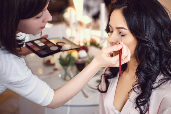 Makeup artist preparing bride before the wedding in a morning — Stock Photo, Image