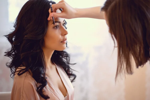 Maquiador preparando noiva antes do casamento em uma manhã — Fotografia de Stock