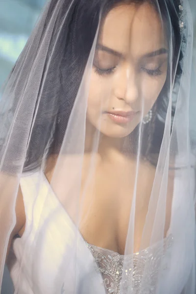 Vackra bruden under brudslöja i en morgon. Bröllopsdag — Stockfoto