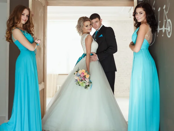 新娘、 新郎和三个伴娘在相似的蓝色连衣裙，有完美的化妆和发型在光的阁楼空间 — 图库照片