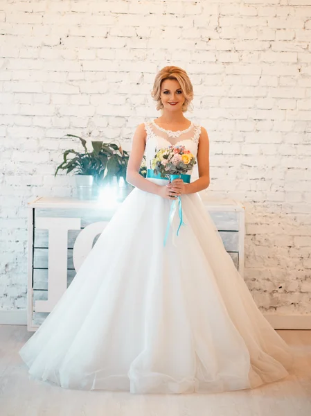 Gorgeous elegant bride in luxury wedding dress in a white loft space — Stock Photo, Image