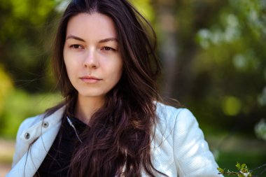 bir yaz bahçesinde ağaçlar çiçek açan genç kadın yürüyor