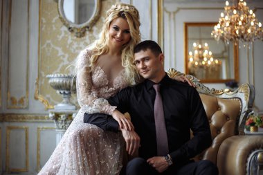 Mükemmel makyaj ve saç stiliyle lüks elbiseli iç siyah giysili bir adam olan güzel kadın