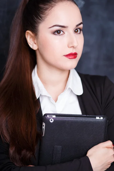 Retrato de una joven mujer de negocios en una chaqueta sosteniendo una tableta sobre una pizarra de tiza —  Fotos de Stock