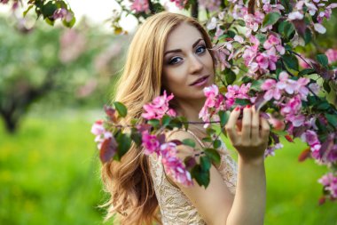 çiçek açan ağaçlar yakınındaki bir yazlık elbise güzel genç kadın