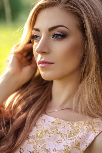 Vacker ung kvinna i en sommarklänning nära blommande träd — Stockfoto