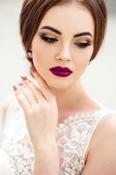 Prachtige bruid met mode make-up en kapsel in een luxe trouwjurk — Stockfoto