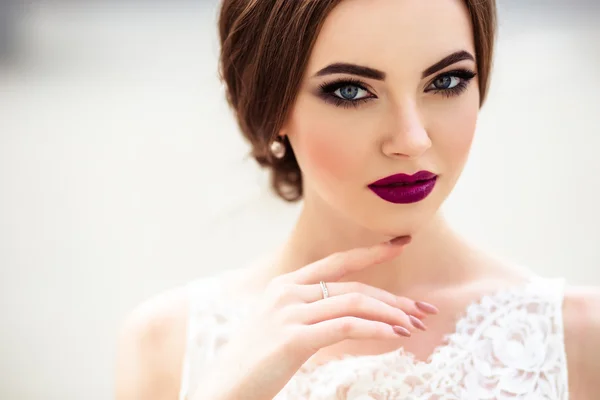 Prachtige bruid met mode make-up en kapsel in een luxe trouwjurk — Stockfoto