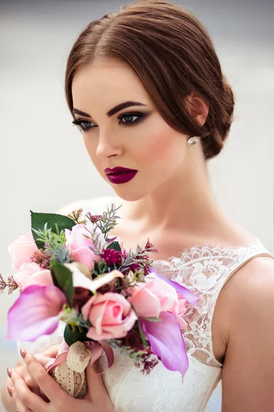 Wunderschöne Braut mit modischem Make-up und Frisur in einem luxuriösen Hochzeitskleid — Stockfoto