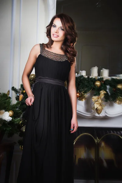 Portrait de belle jeune femme en robe de soirée sur fond de Noël — Photo