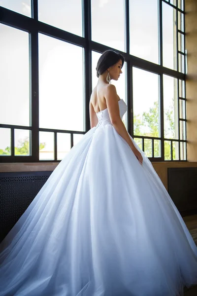 Foto de uma bela noiva morena em um vestido de casamento luxuoso em interior elegante — Fotografia de Stock