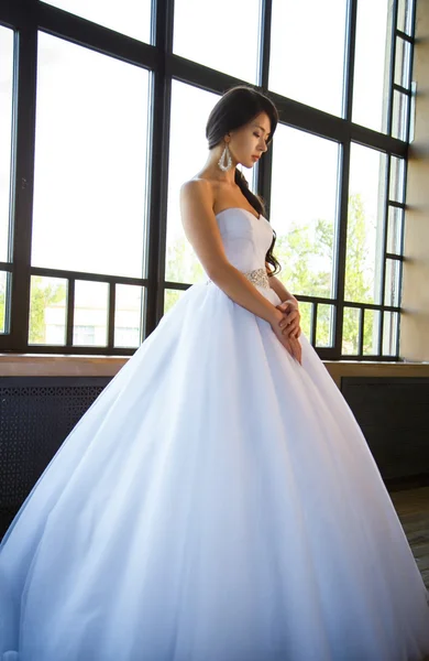 Фото красивой брюнетки невесты в роскошном свадебном платье в элегантном интерьере — стоковое фото
