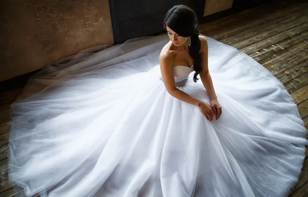 Foto de una hermosa novia morena en un lujoso vestido de novia en un elegante interior — Foto de Stock