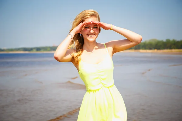 Süßes junges Mädchen in hübschem gelben Kleid am Strand — Stockfoto