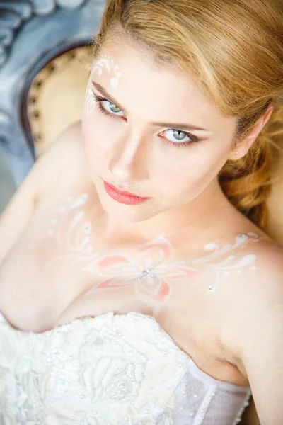 Schöne blonde Braut mit perfektem Make-up und Frisur im eleganten Interieur — Stockfoto