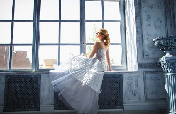 Красивая блондинка невеста с идеальным макияжем и прической в элегантном интерьере — стоковое фото