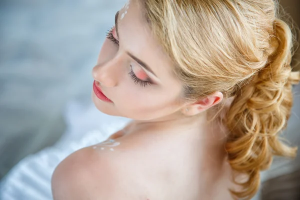 Schöne blonde Braut mit perfektem Make-up und Frisur im eleganten Interieur — Stockfoto