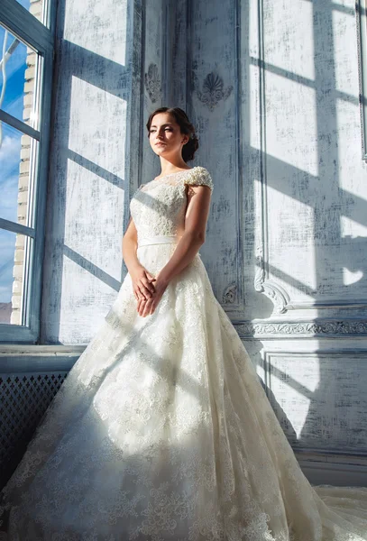 Foto di una bella sposa bruna in un abito da sposa di lusso in eleganti interni costosi — Foto Stock