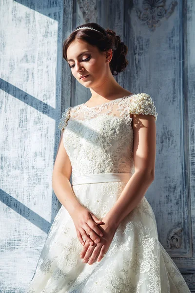 Foto di una bella sposa bruna in un abito da sposa di lusso in eleganti interni costosi — Foto Stock