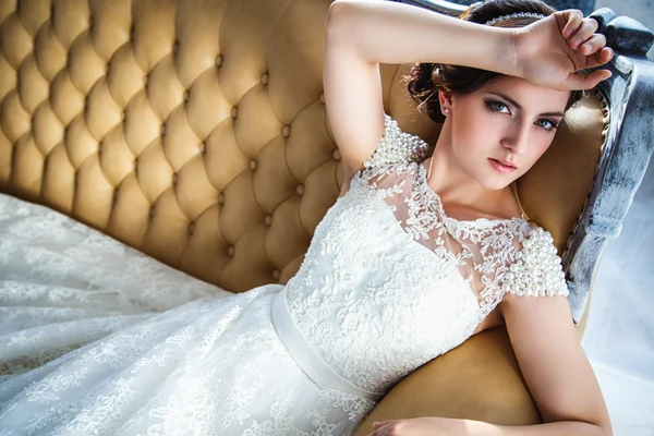 Foto di una bella sposa bruna in un abito da sposa di lusso in eleganti interni costosi — Foto Stock