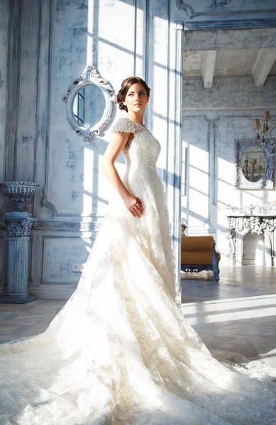 Foto di una bella sposa bruna in un abito da sposa di lusso in eleganti interni costosi — Foto Stock