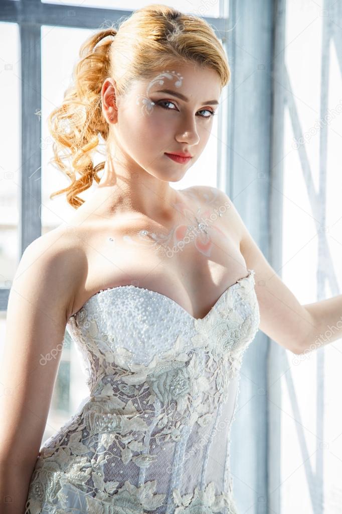 Beautiful blonde bride with perfect makeup and hair style in elegant interior