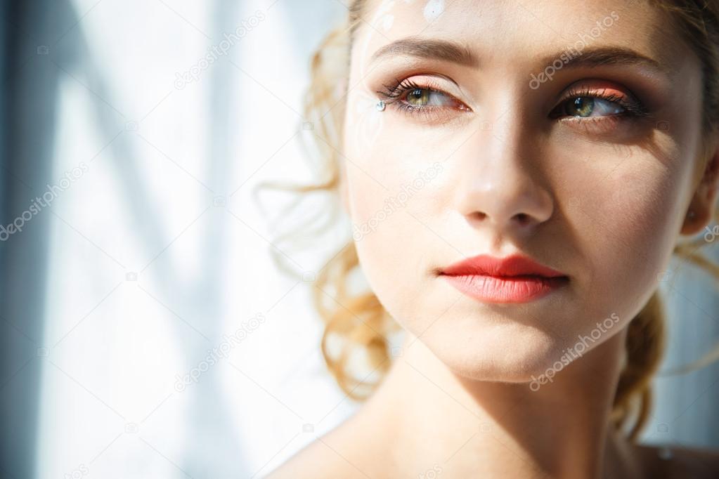 Beautiful blonde bride with perfect makeup and hair style in elegant interior