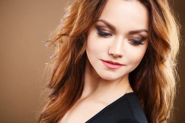 Close-up portrait of beautiful sexy young woman with long brown hair over brown background — Stock Photo, Image