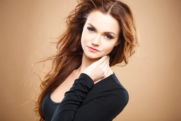 Közelkép hosszú barna hajjal, barna háttér felett a gyönyörű szexi fiatal nő portréja — Stock Fotó