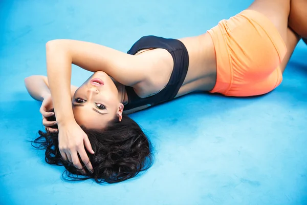 Dolce e sexy bruna giovane donna in stile sportivo su sfondo blu — Foto Stock