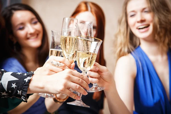 Весёлые девушки звонят в бокалы шампанского на вечеринке — стоковое фото