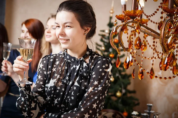 Porträt einer schönen jungen Frau mit einem Glas Champagner, die mit Freunden das neue Jahr feiert — Stockfoto