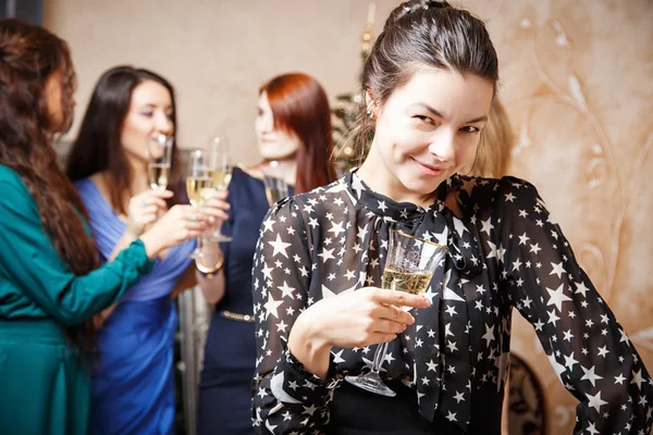 Porträt einer schönen jungen Frau mit einem Glas Champagner, die mit Freunden das neue Jahr feiert — Stockfoto