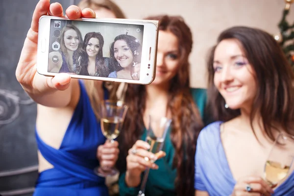 Група красивих молодих жінок в келихах шампанського роблять фото на смартфон — стокове фото
