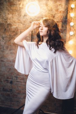 Makyaj odasında muhteşem akşam elbiseli güzel zarif genç kadın portresi