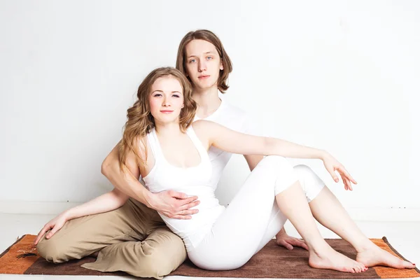 Pareja joven en pose de yoga — Foto de Stock