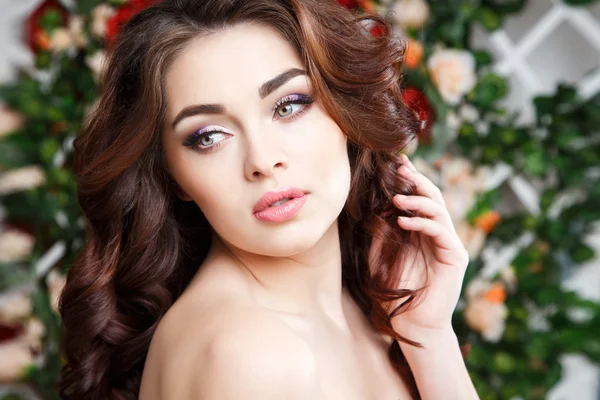 Close-up retrato de bela jovem com maquiagem perfeita e estilo de cabelo com flores no cabelo — Fotografia de Stock