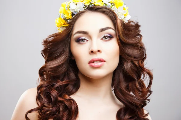 Retrato de cerca de una hermosa mujer joven con maquillaje perfecto y peinado con flores en el cabello — Foto de Stock