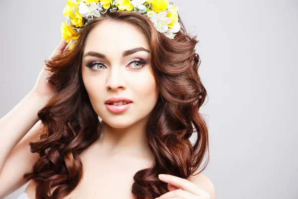 Retrato de cerca de una hermosa mujer joven con maquillaje perfecto y peinado con flores en el cabello — Foto de Stock