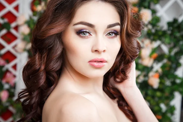 Gyönyörű fiatal nő, a tökéletes smink és frizura haj virágok közelről portréja — Stock Fotó