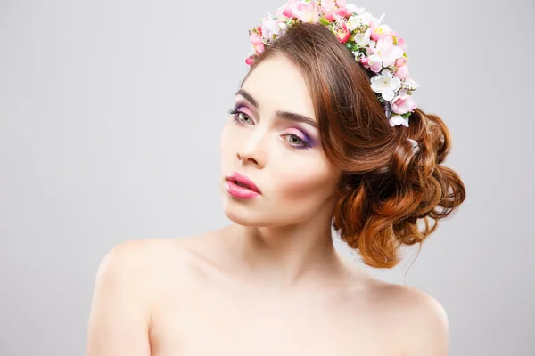 Крупный план портрета красивой молодой женщины с идеальным макияжем и прической с цветами в волосах — стоковое фото
