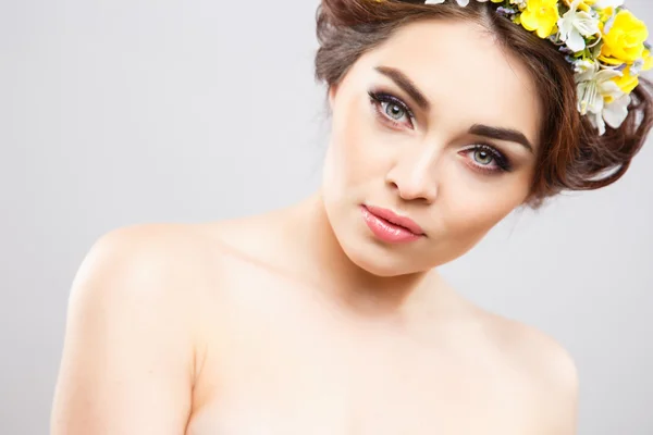 Retrato de cerca de una hermosa mujer joven con maquillaje perfecto y peinado con flores en el cabello — Foto de Stock