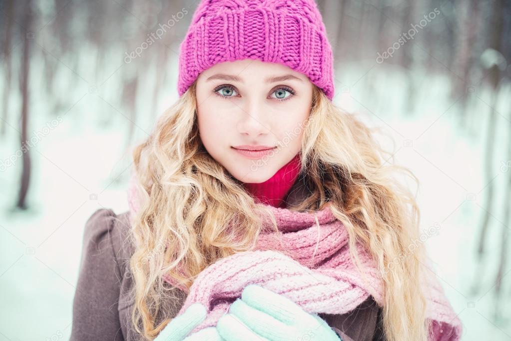 Pretty blonde girl walking in a winter park