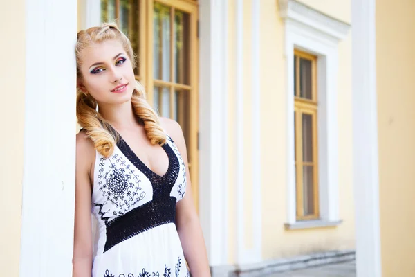 Jolie jeune fille blonde près de la magnifique maison avec des colonnes en été — Photo