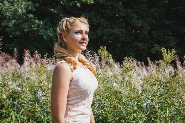 Όμορφη ξανθιά κοπέλα σε άνθηση πεδίο σε ένα καλοκαίρι — Φωτογραφία Αρχείου