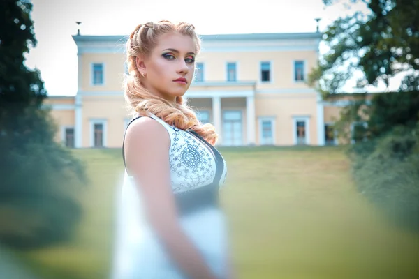 Krásná mladá blondýnka v blízkosti nádherné domu se sloupci v létě — Stock fotografie