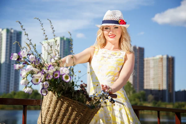 Krásná sladká blondýnka chodí s kole poblíž mrakodrapy — Stock fotografie