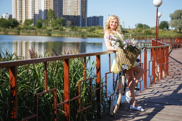 Schöne süße blonde Frau läuft mit dem Fahrrad in der Nähe von Wolkenkratzern — Stockfoto
