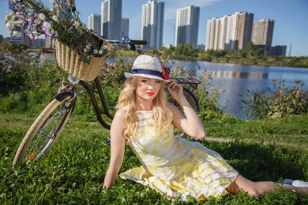 Schöne süße blonde Frau läuft mit dem Fahrrad in der Nähe von Wolkenkratzern — Stockfoto